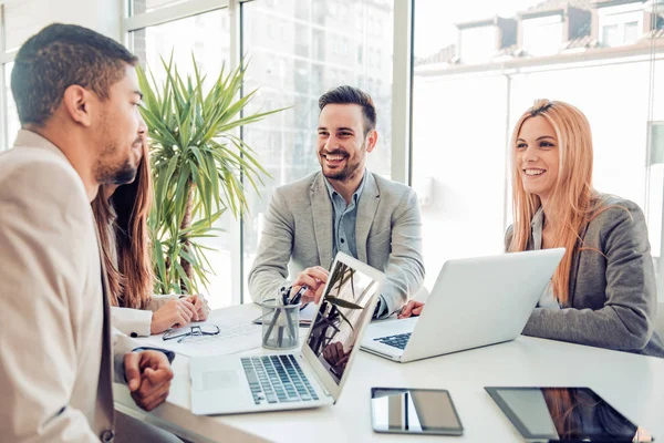 Uśmiechnięta kobieta pracująca przy laptopie w kawiarni